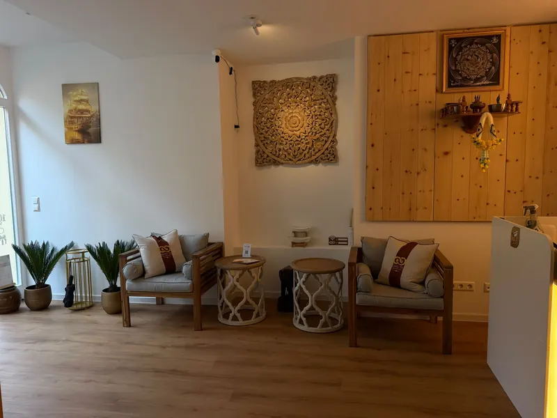 Lounge mit thailändischer Holzschnitzerei und Palmen
